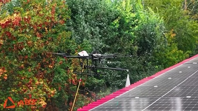 Drona lângă vegetație, spălând panouri pe acoperiș